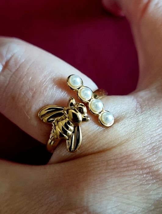 Anel dourado, em aço, com abelha e 4 micropérolas. Ajustável